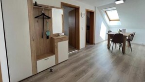 Et værelse med garderobeskab, skrivebord og spisebord.