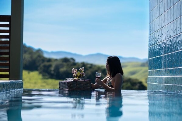 A person in a hot tub with a view of mountains in the background.