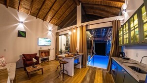 Een moderne woonkamer met een open haard, een eethoek en een keuken met een groot raam.