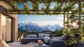 A modern outdoor seating area with a view of snow-capped mountains. - Wieshof Wilder Kaiser by ALPS RESORTS (Soell)