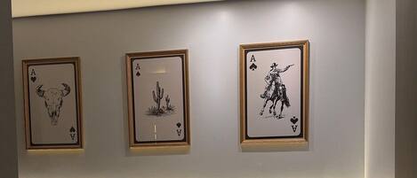 A hotel room with a bed, pillows, a nightstand, and wall art.