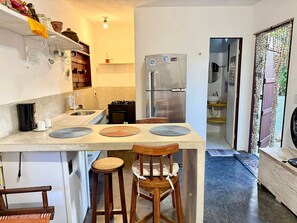 Une cuisine de taille réduite avec un îlot central, un réfrigérateur et un évier.