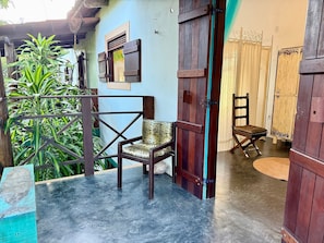 Une pièce avec une porte en bois, une chaise, une table et une vue sur l’extérieur.