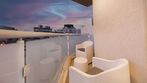 A balcony with white chairs and a glass partition, overlooking a cityscape with modern buildings. - Spacious 2BR Podium Marina near Valletta (Msida)