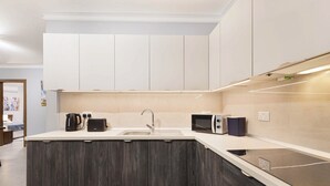 A modern kitchen with a built-in microwave, kettle, and sink. - Spacious 2BR Podium Marina near Valletta (Msida)