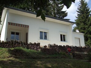 A two-story building with a stone wall foundation, multiple windows, and a visible door. - MAISON AYDAT AUVERGNE BORD DE LAC AYDAT (Aydat)