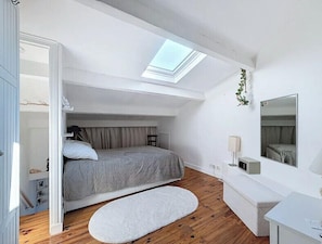 A compact bedroom with a skylight, a bed, a bedside table, a mirror, and a small desk. - Apartment, terrace sea view in Saint-Raphaël (Saint-Raphaël)