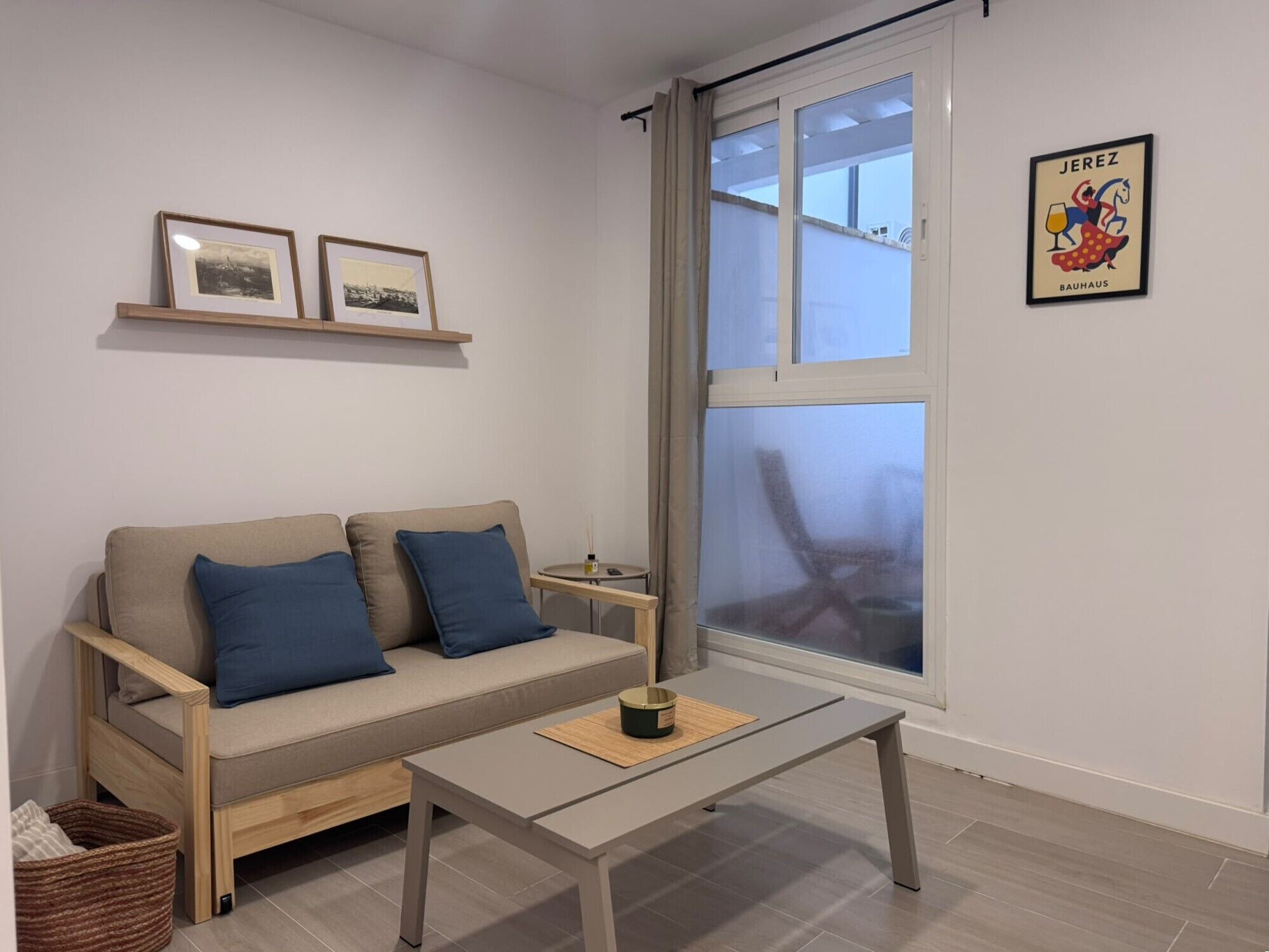 Ein modernes Wohnzimmer mit einer Couch, einem Couchtisch und einem großen Fenster.