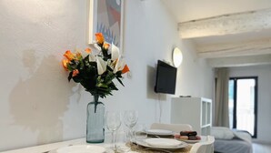 Ein Esstisch mit Tellern, Gläsern und einer Blumenvase.