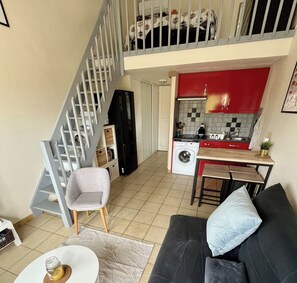 A compact living space with a staircase, a kitchenette, a sofa, and a dining area. - Studio in Sainte-Marie-la-Mer near the beach (Sainte-Marie-la-Mer)