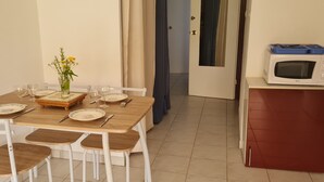 Una mesa de comedor dispuesta con platos, cubiertos y un florero.