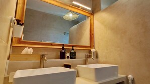 Ein modernes Badezimmer mit zwei Waschbecken, einem großen Spiegel und einer Deckenleuchte.
