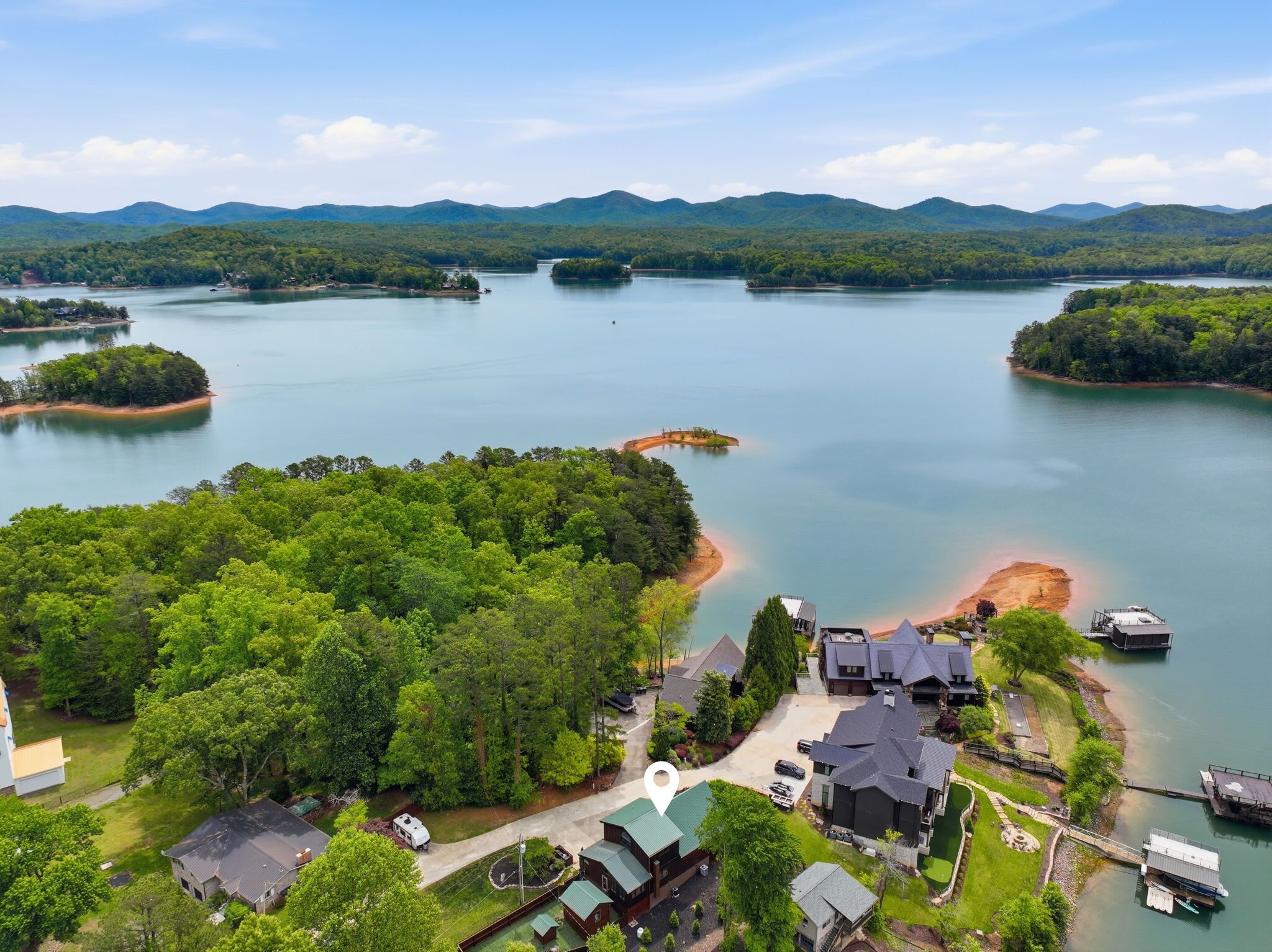 A lakeside property with multiple buildings, a dock, and a boat.