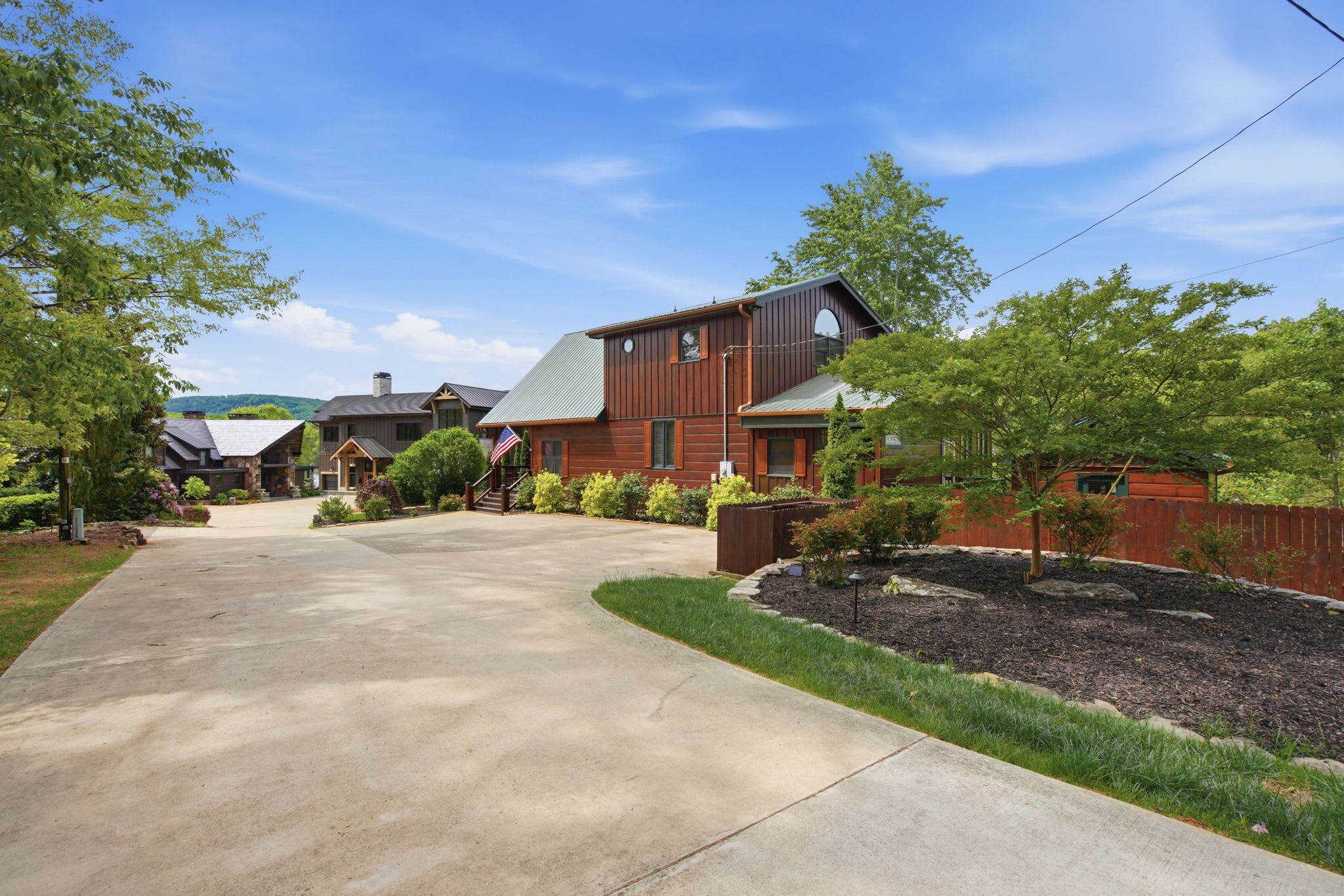A residential street with houses, a clear sky, and a well-maintained driveway.