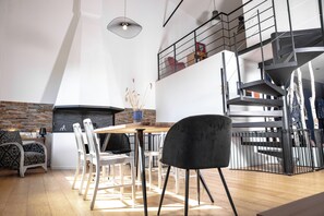 Ein modernes Interieur mit Essbereich, Treppe und Kamin.
