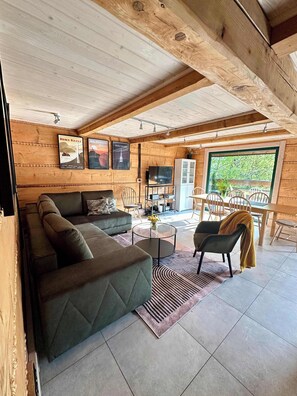 Un interior de madera acogedor con sofá, mesa de centro y comedor.