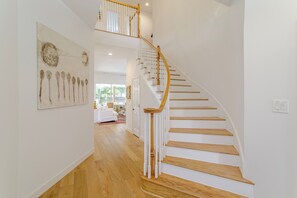 A staircase with wooden steps and white balusters, leading to an upper level. - Cozy House Retreat Near Texas Medical Center. (Houston)