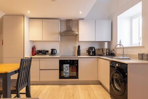 A compact kitchen with a built-in oven, dishwasher, and coffee maker. - Cosy 1 bed close to Chester, parking! (Cheshire West and Chester)