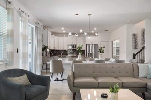 Ein modernes Wohnzimmer mit Sofa, Sessel und Couchtisch.