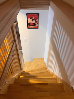 Eine Holztreppe mit einem gerahmten Bild an der Wand.