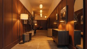 A hallway with a wooden floor, a desk with a lamp, a mirror, and a suitcase. - Ceros (Denver)