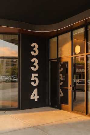 A building entrance with large glass doors and a black facade.