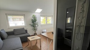Una sala de estar moderna con un sofá, una mesita y una zona de ducha.
