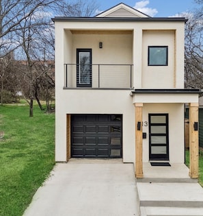 A two-story house with a garage, a balcony, and a front door. - Modern House with Dallas Skyline Views! (Dallas)