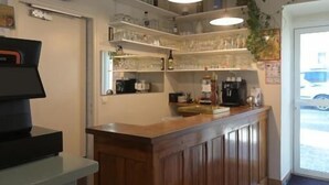 Een keuken met een houten aanrechtblad, hangende pendantlampen en uitzicht op de straat door een glazen deur.