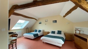 Een slaapkamer met twee bedden, een bureau, een stoel en een dressoir.