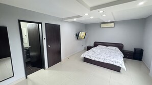 Una camera da letto moderna con un letto grande, una TV e un soffitto con faretti.