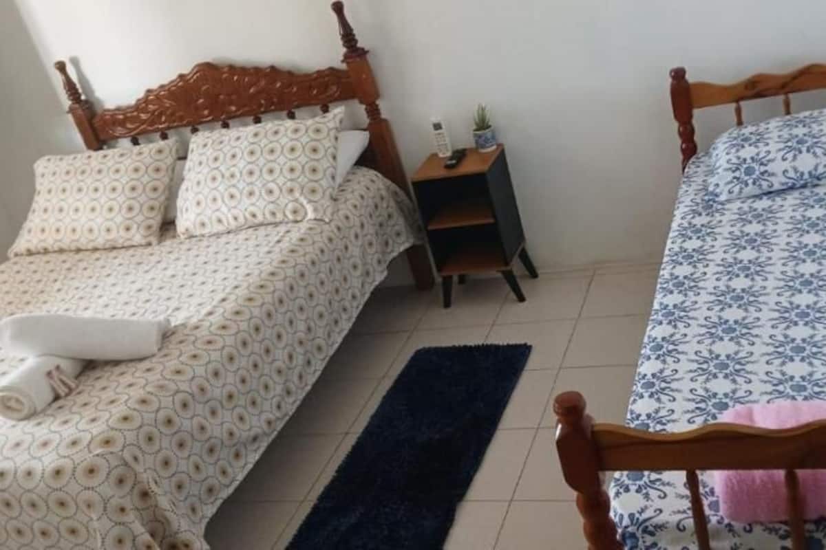 Un dormitorio con dos camas, una mesita de noche y una pequeña mesa.