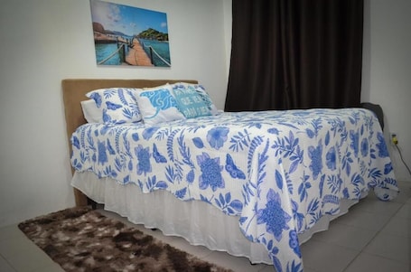 A bedroom with a bed, a pillow, a rug, a wall with a painting, and a curtain.. Pousada Imperatriz