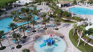 Ein Resort mit mehreren Swimmingpools, Palmen und einer zentralen Wasserspielfläche.