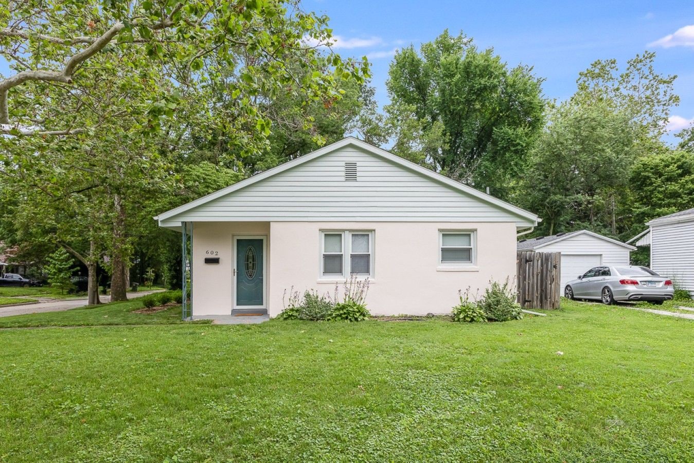 A single-story house with a front door, two windows, and a mailbox.