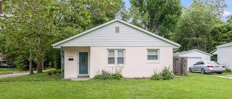 A single-story house with a front door, two windows, and a mailbox.
