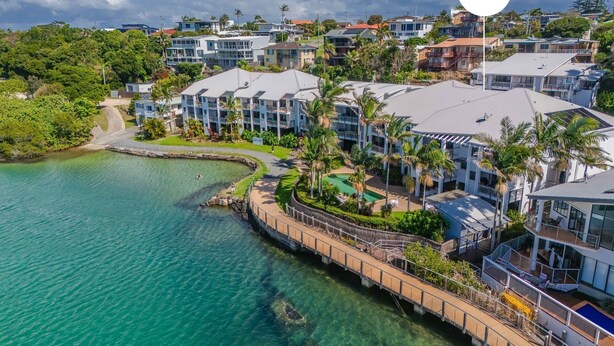 Un hotel costero con varias edificaciones, vistas despejadas al océano y un jardín bien cuidado.