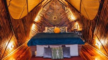 A tent-style room with a bed, pillows, and a decorative wall pattern.