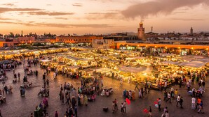 Un mercado al aire libre con numerosos puestos y gente.