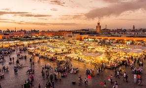 A bustling outdoor market with numerous stalls and people. - Palais Talilit (Marrakech)