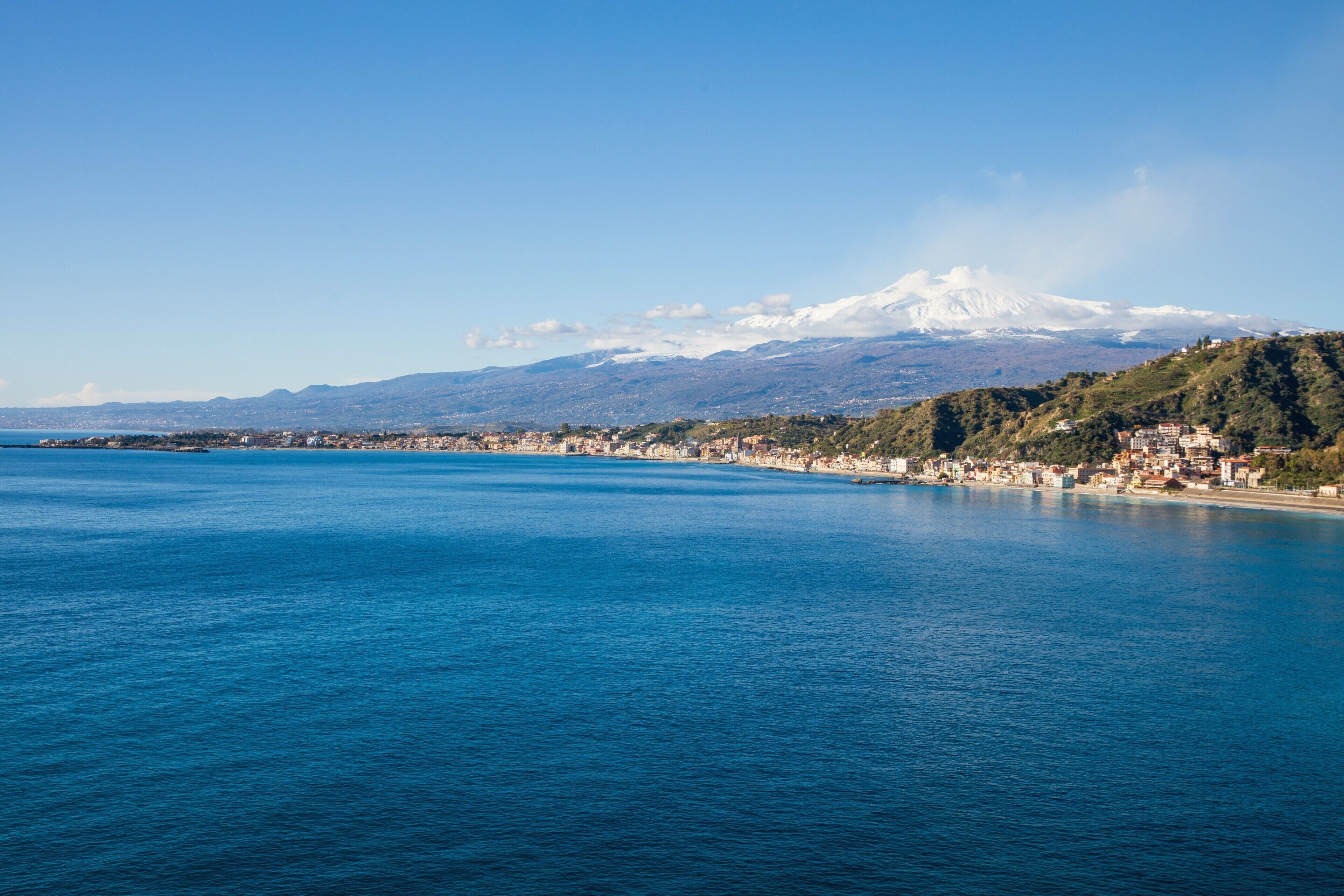A coastal city with a mountain in the background.