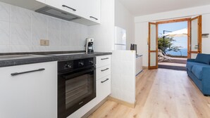 Eine moderne Küche mit weißen Schränken, einem Backofen und einer Kaffeemaschine.
