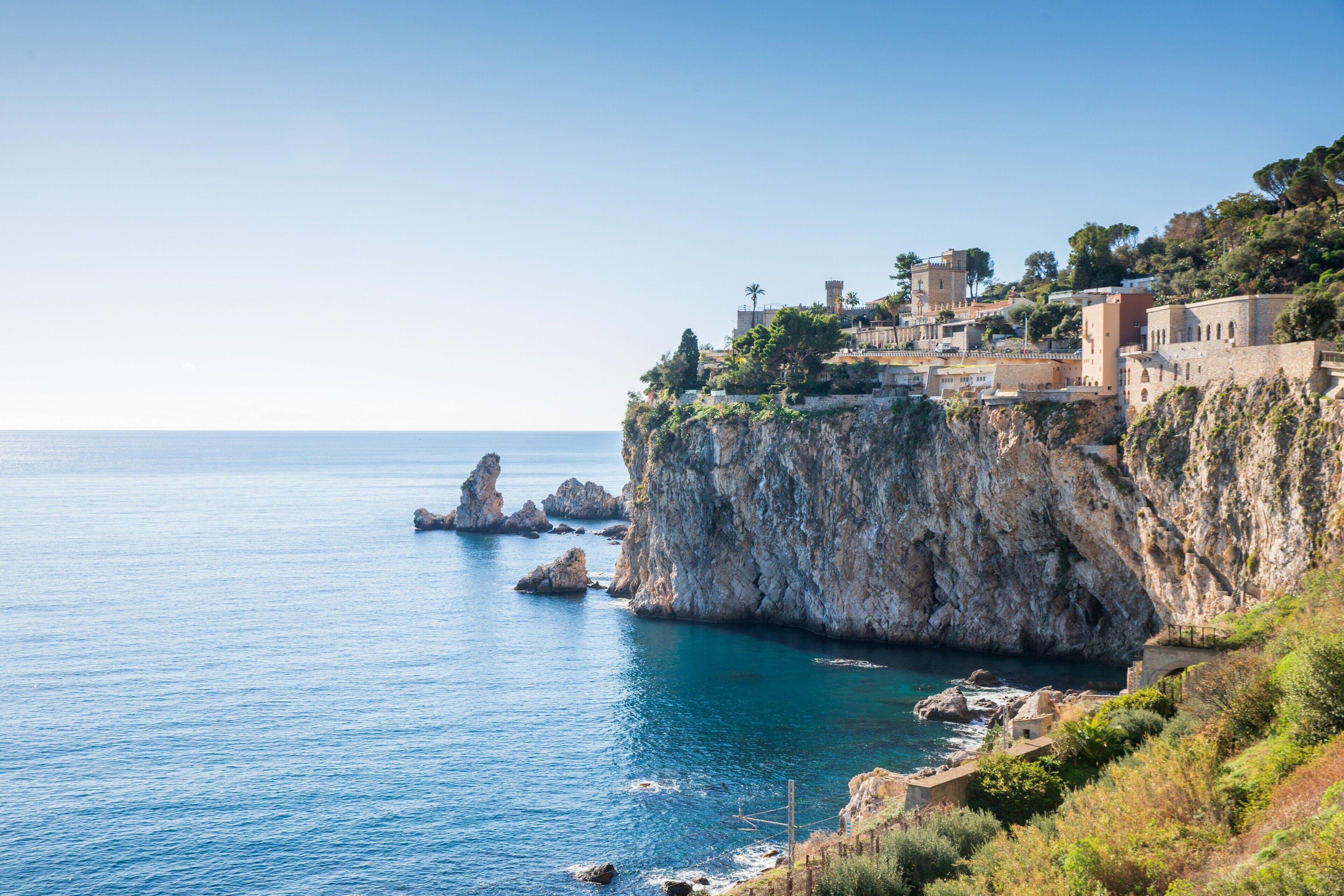 A coastal town with buildings on a cliff overlooking the sea.