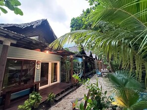 A wooden building with a porch, a hammock, and a small seating area.
