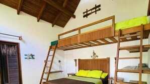 A room with a bunk bed, a ladder, a small table, and a window with blinds. - Cabañas Kai  (Iztapa)