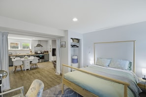 A bedroom with a bed, a desk, and a kitchenette. - Urban oasis, Central District - Studio (Seattle)