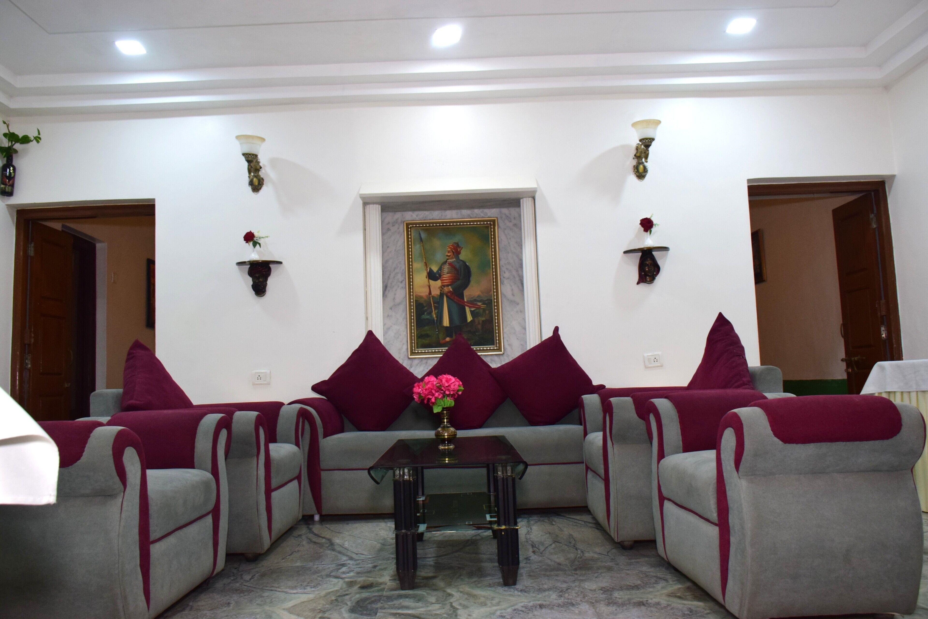 A living room with a sofa set, a coffee table, and a painting on the wall.