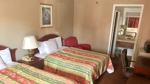A hotel room with two beds, a desk, a chair, a lamp, and a painting on the wall. - Days Inn by Wyndham Victorville/hesperia I-15 & P (Victorville)