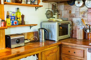 Una cocina con microondas, tostadora y diferentes utensilios de cocina sobre la encimera.