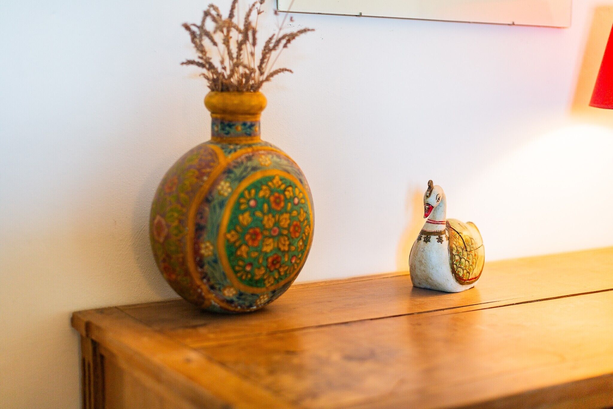 Uma mesa de madeira com um vaso decorativo e uma figurina.